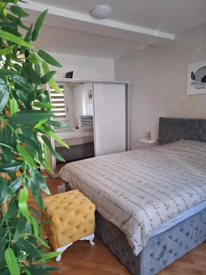 a bedroom with a bed and a large green plant at Valia apartments in Belgrade