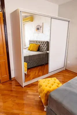 a mirror in a room with a bed and a couch at Valia apartments in Belgrade