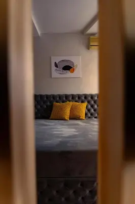 a bed with two yellow pillows in a room at Valia apartments in Belgrade