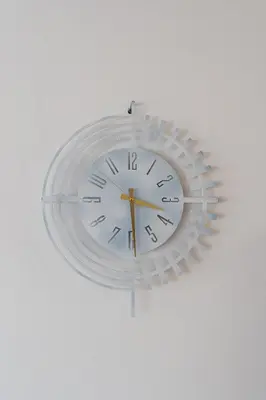 a white clock is hanging on a wall at Valia apartments in Belgrade