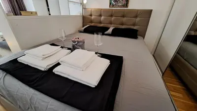 a room with two beds with white towels and wine glasses at Maya 's home - Vracar in Vračar (historical)
