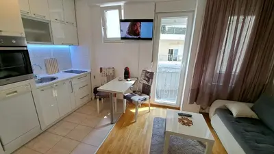 a kitchen with white cabinets and a table and a couch at Maya 's home - Vracar in Vračar (historical)