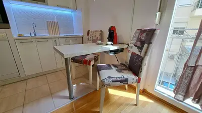 a small kitchen with a table and a chair at Maya 's home - Vracar in Vračar (historical)