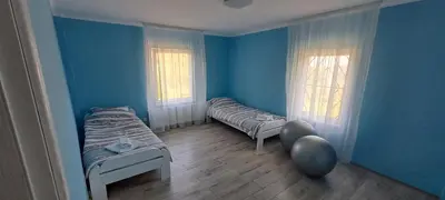 two beds in a room with blue walls at Vila Felicita in Sremski Karlovci