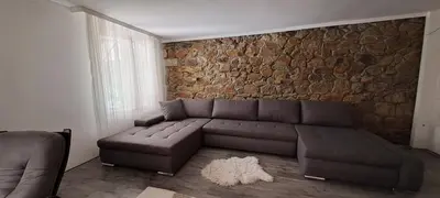 a living room with a couch and a stone wall at Vila Felicita in Sremski Karlovci