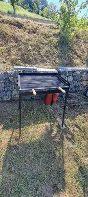 a bench sitting in the grass next to a wall at Vila Felicita in Sremski Karlovci