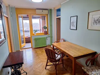 a dining room with a wooden table and chairs at Apartment Casper in Belgrade