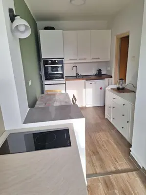 a kitchen with white cabinets and a counter top at Apartment Casper in Belgrade