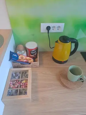 a table with a cup of coffee and a tea pot at Apartment Ivon in Belgrade
