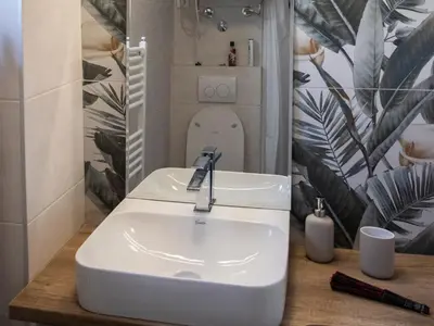 a bathroom with a sink with a toilet in the mirror at Apartment Ivon in Belgrade