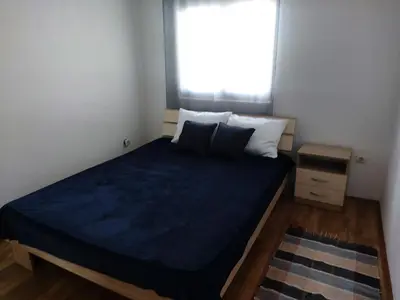 a small bedroom with a blue bed with a window at LB boka 216 in Mali Mokri Lug