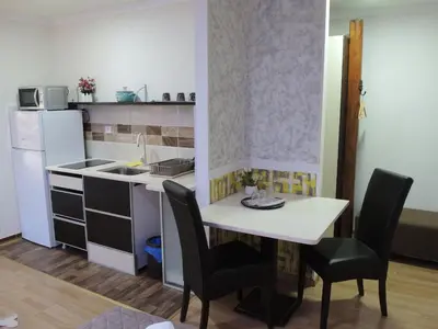 a small kitchen with a white table and chairs at Apartmani Beograd 43 in Belgrade