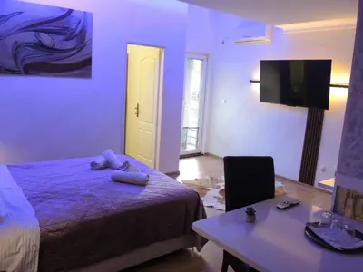 a bedroom with a bed and a desk and a tv at Apartmani Beograd 43 in Belgrade