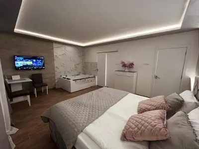 a bedroom with a large bed and a tv at S class apartment in Novi Grad
