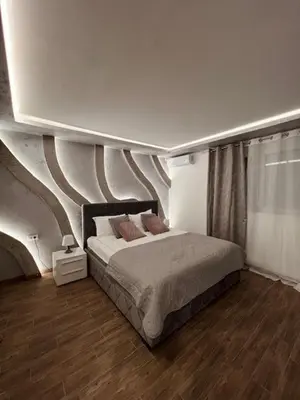 a bedroom with a bed with a painting on the wall at S class apartment in Novi Grad