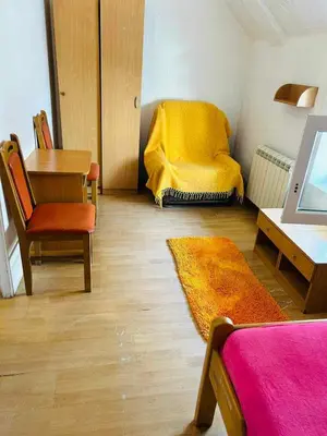 a living room with a yellow couch and a table at Rooms for rent 