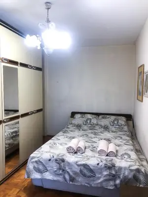 a bedroom with a bed with slippers on it at Maki NBG in Belgrade