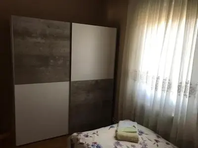 a bedroom with a bed with a curtain and a window at Apartman Irena in Mali Mokri Lug