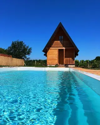 a house with a pool in front of it at Kućica naša bajka in Kupinovo
