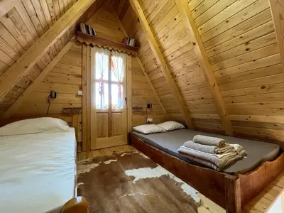 a room with two beds in a log cabin at Kućica naša bajka in Kupinovo