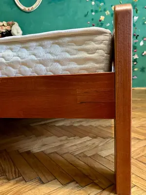 a bed with a wooden frame on a wooden floor at Creative Apartment Kaleidoscope in Belgrade