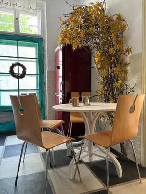 a table and chairs in a room with a plant at Creative Apartment Kaleidoscope in Belgrade