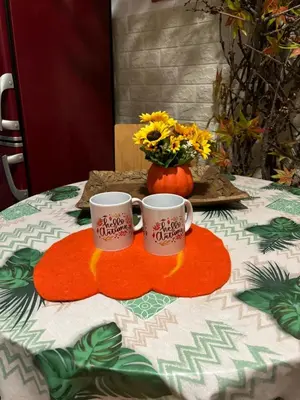 two coffee cups on a table with a vase of flowers at Creative Apartment Kaleidoscope in Belgrade