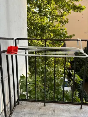 a table on a balcony with red umbrellas on it at Creative Apartment Kaleidoscope in Belgrade