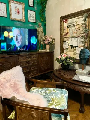a living room with a tv and a table and a mirror at Creative Apartment Kaleidoscope in Belgrade