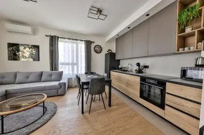 a kitchen and living room with a couch and a table at Modern apartment on the Belgrade Waterfront in Belgrade