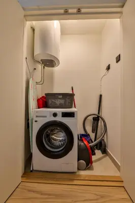 a laundry room with a washing machine in a hallway at Modern apartment on the Belgrade Waterfront in Belgrade