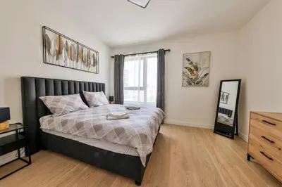 a bedroom with a large bed and a dresser at Modern apartment on the Belgrade Waterfront in Belgrade