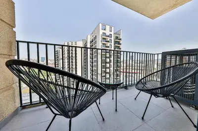 a balcony with two chairs and a view of a city at Modern apartment on the Belgrade Waterfront in Belgrade