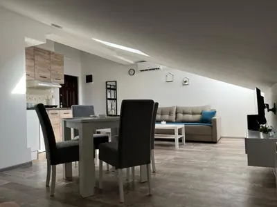 a dining room and living room with a table and chairs at Apartman 24 in Arandjelovac