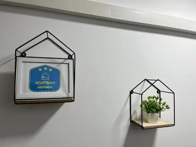a sign on a wall with a potted plant at Apartman 24 in Arandjelovac