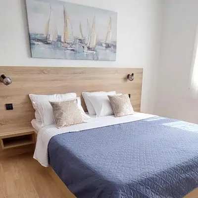 a bedroom with a bed and a painting of sailboats at Apartment Roosevelt in Belgrade