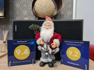 a santa claus figurine standing next to two certificates at Apartment Roosevelt in Belgrade