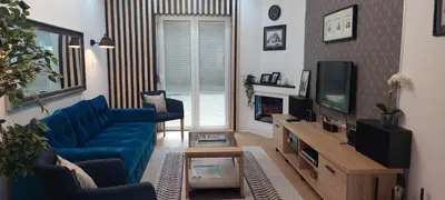 a living room with a blue couch and a tv at Apartment Roosevelt in Belgrade