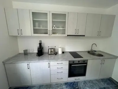 a kitchen with white cabinets and a counter top at Kosmaj Ruža vetrova in Sopot