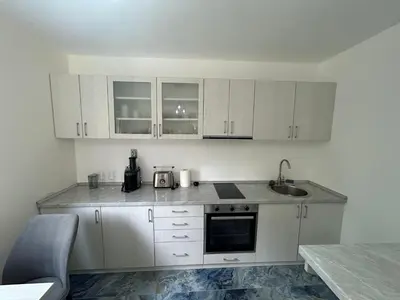 a kitchen with white cabinets and a sink at Kosmaj Ruža vetrova in Sopot