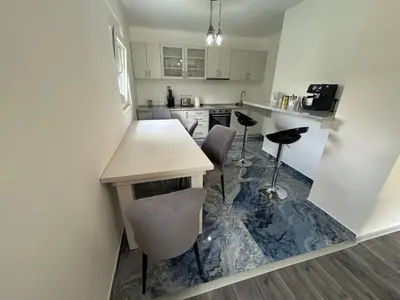 a kitchen with a table and some chairs in it at Kosmaj Ruža vetrova in Sopot