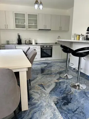 a kitchen with a marble floor with a table and stools at Kosmaj Ruža vetrova in Sopot