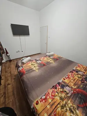 a bed in a room with a blanket on it at Kalina Apartman in Belgrade