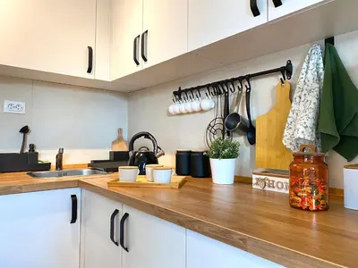 a kitchen with white cabinets and a wooden counter top at Košutica Vila in Koraćica