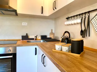 a kitchen with white cabinets and a wooden counter top at Košutica Vila in Koraćica