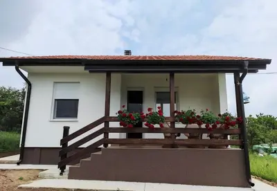 a house with a porch with flowers on it at Košutica Vila in Koraćica