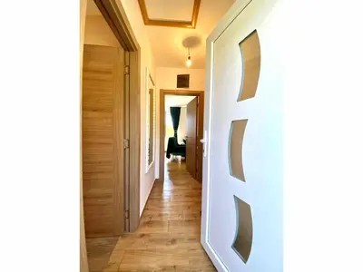 a hallway with a white wall with a wooden floor at Košutica Vila in Koraćica