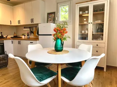 a kitchen with a white table with a vase of flowers at Košutica Vila in Koraćica