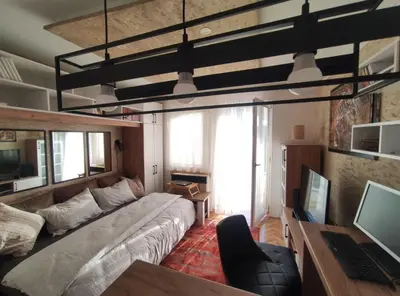 a living room with a large bed and a desk at Apartman Osmeha in Mladenovac