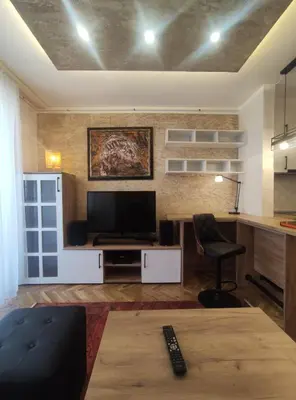 a living room with a television and a chair at Apartman Osmeha in Mladenovac